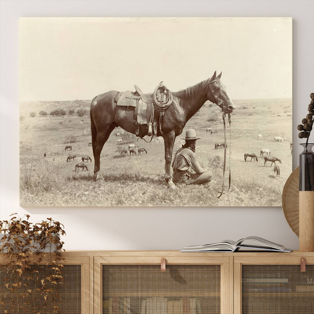 Cowboy Wall Art - Vintage Western Horse Canvas Print features a cowboy kneeling by his horse in a field.