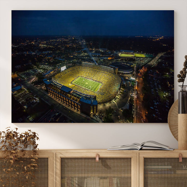 Aerial view of Michigan Stadium at night, surrounded by city lights, depicted on a Michigan Wolverines wall art canvas print.