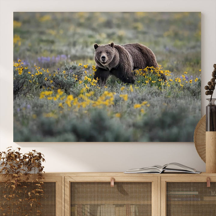 The "Grizzly 399 in Wild Flowers Wall Art Canvas Print" features a grizzly bear strolling through a field of yellow and purple flowers, beautifully showcased as a triptych. This handcrafted piece, proudly made in the USA, adds charm and sophistication to your space.