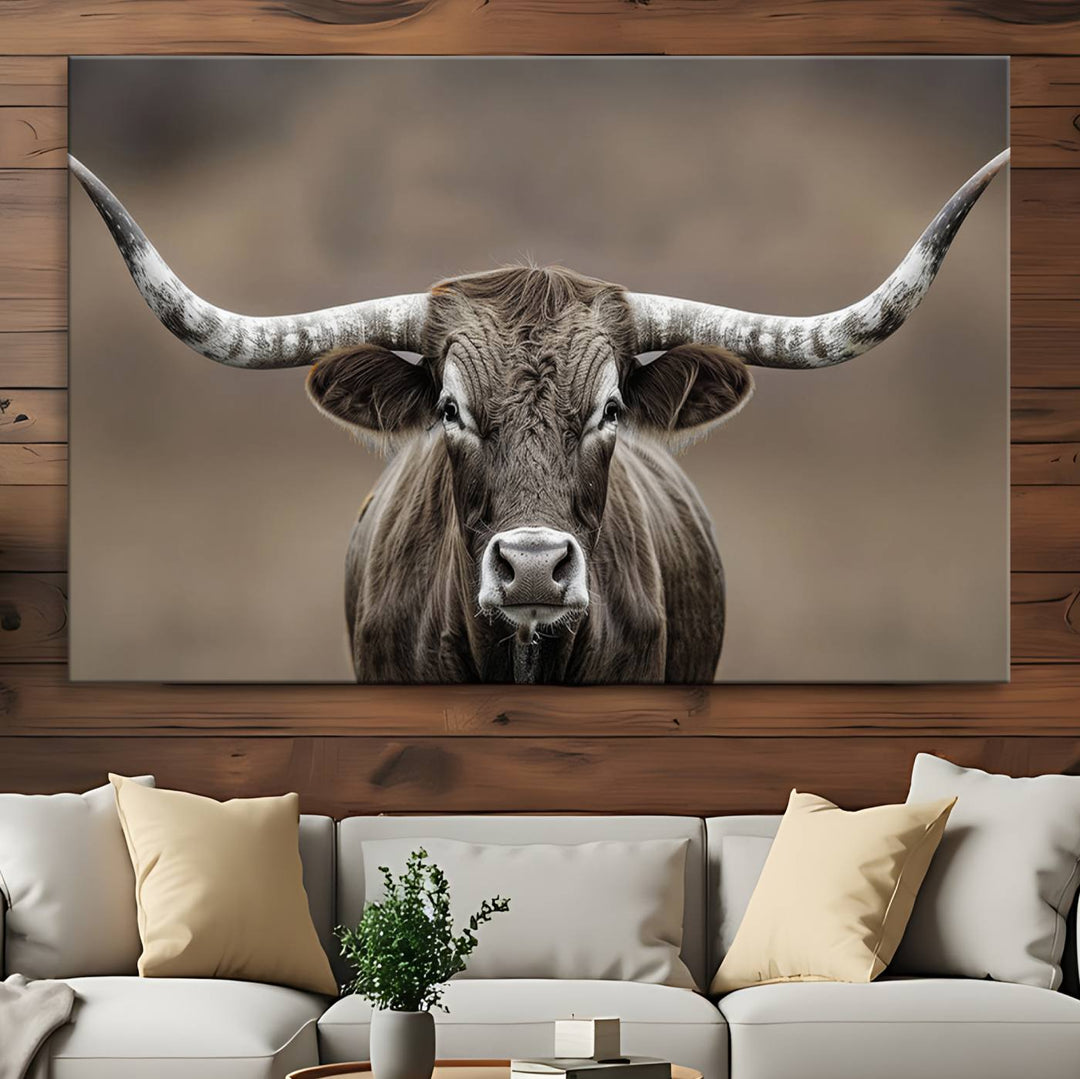 A close-up of a longhorn bull facing forward is featured in the Framed Texas Test-1, set against a blurred brown background.