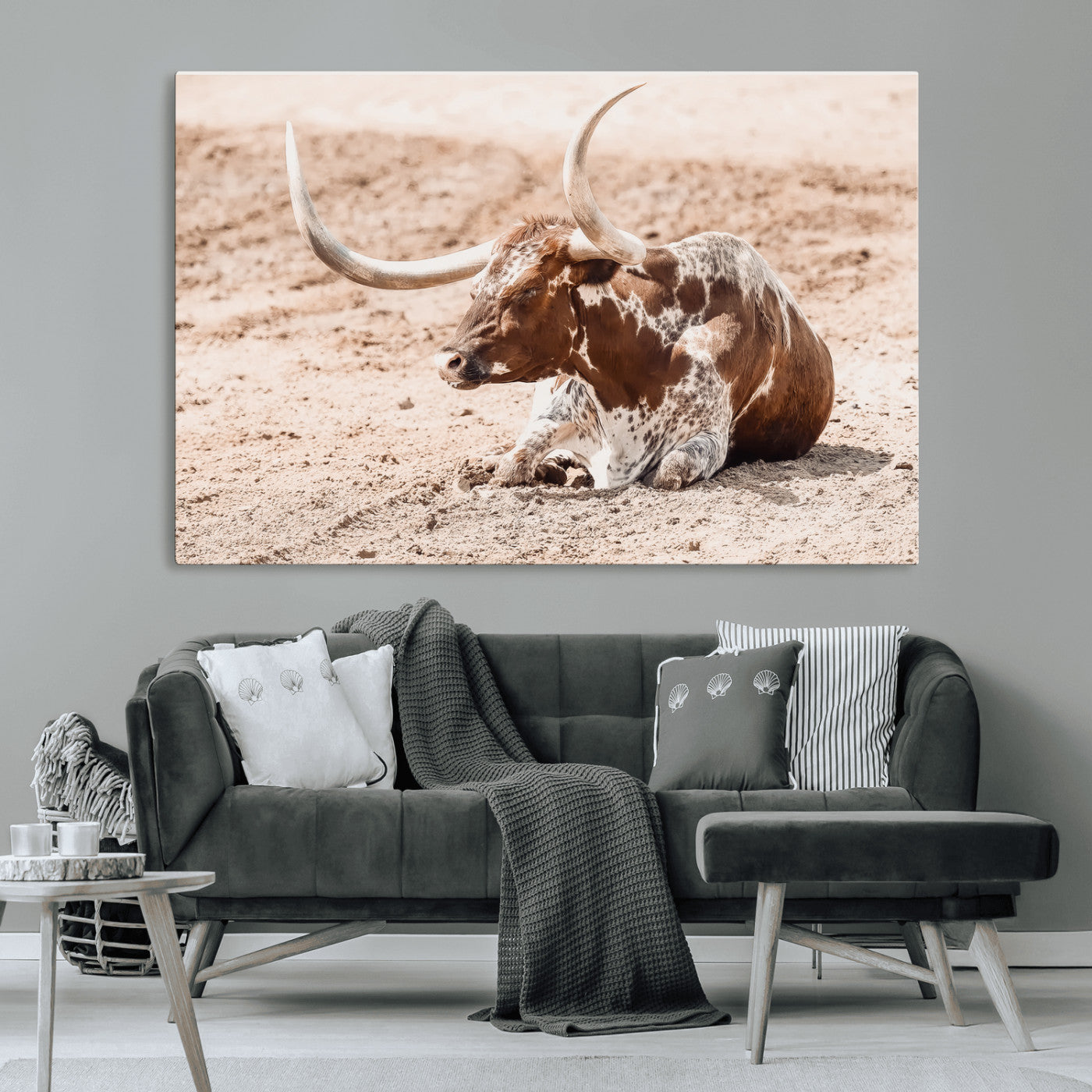 Texas Longhorn bull resting on dusty ground with warm tones, ideal for rustic western or farmhouse-themed wall decor.
