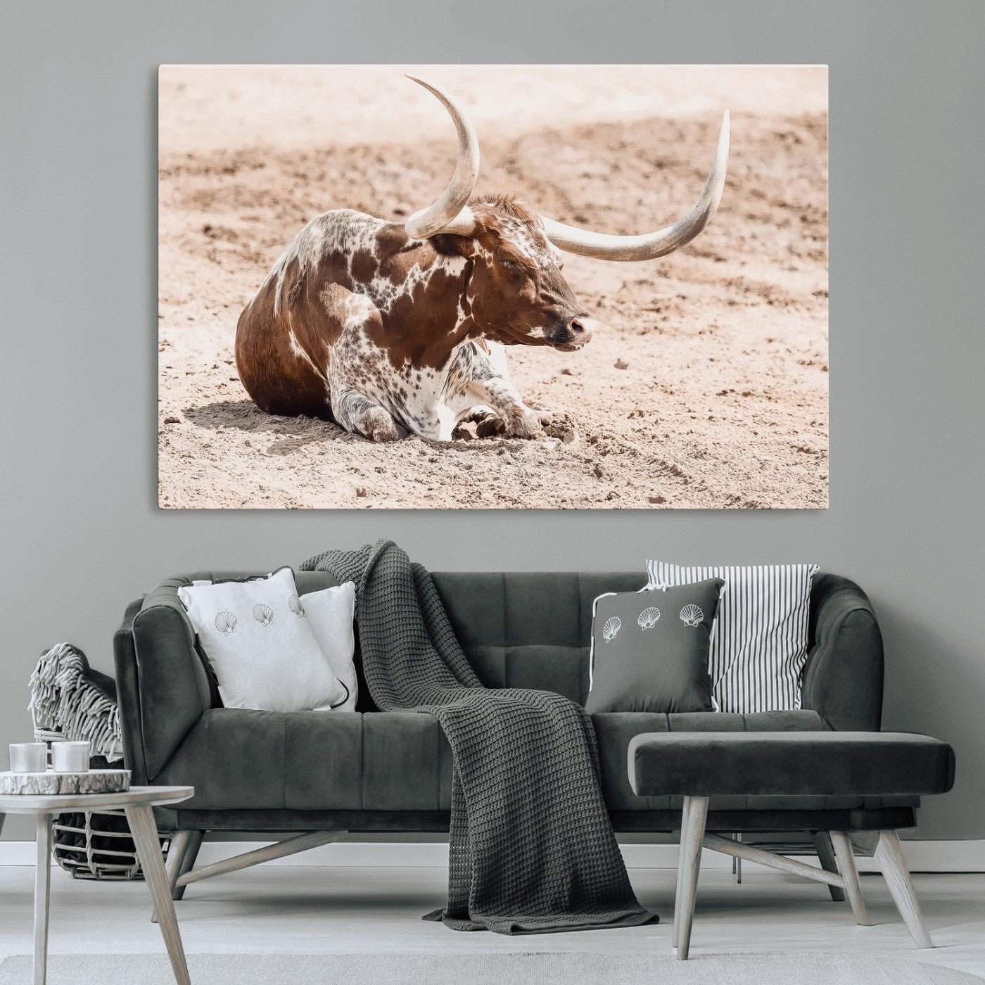 Texas Longhorn bull resting on dusty ground with warm tones, ideal for rustic western or farmhouse-themed wall decor.