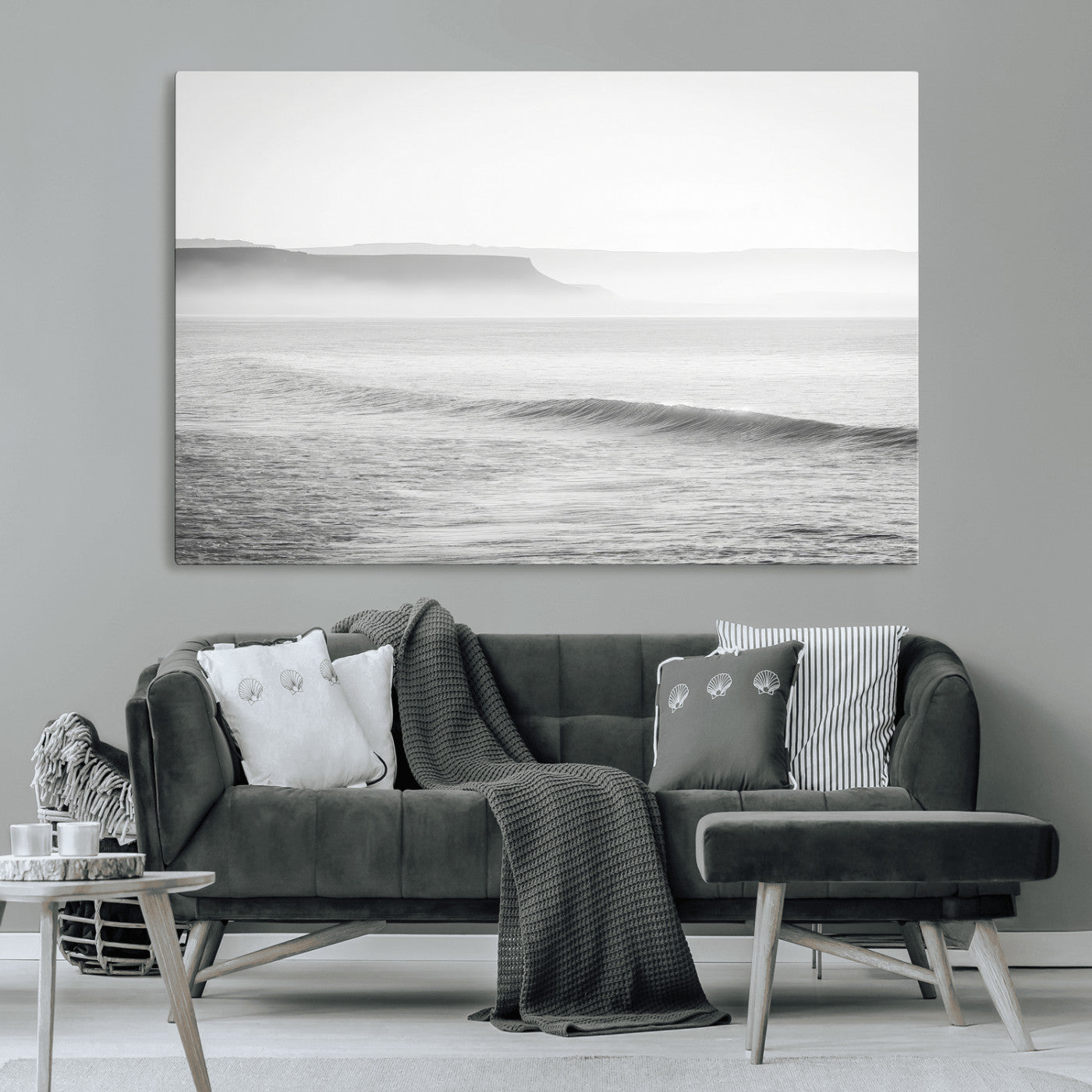 A black and white minimalist seascape featuring soft rolling waves and misty distant cliffs, creating a serene and timeless coastal atmosphere.