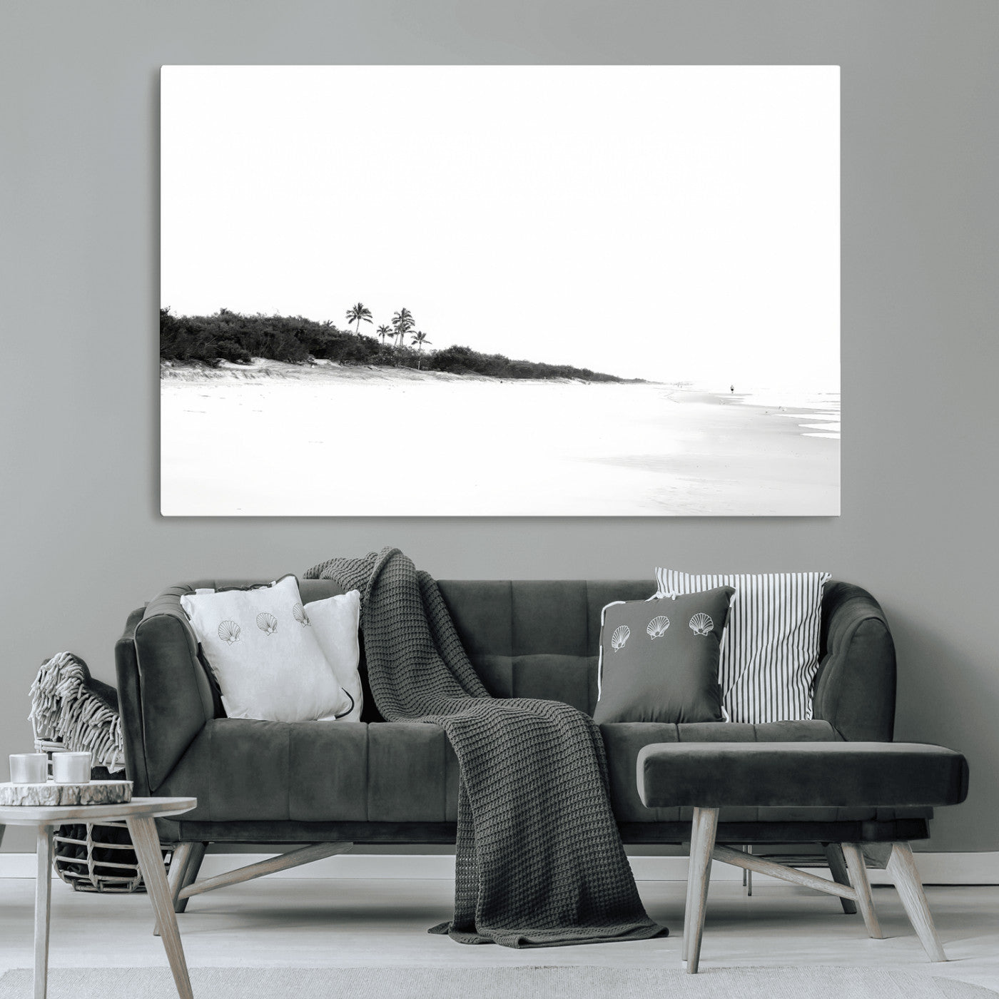 A black and white minimalist coastal scene with a vast open beach, distant palm trees, and a lone figure walking along the shoreline, evoking serenity and solitude.