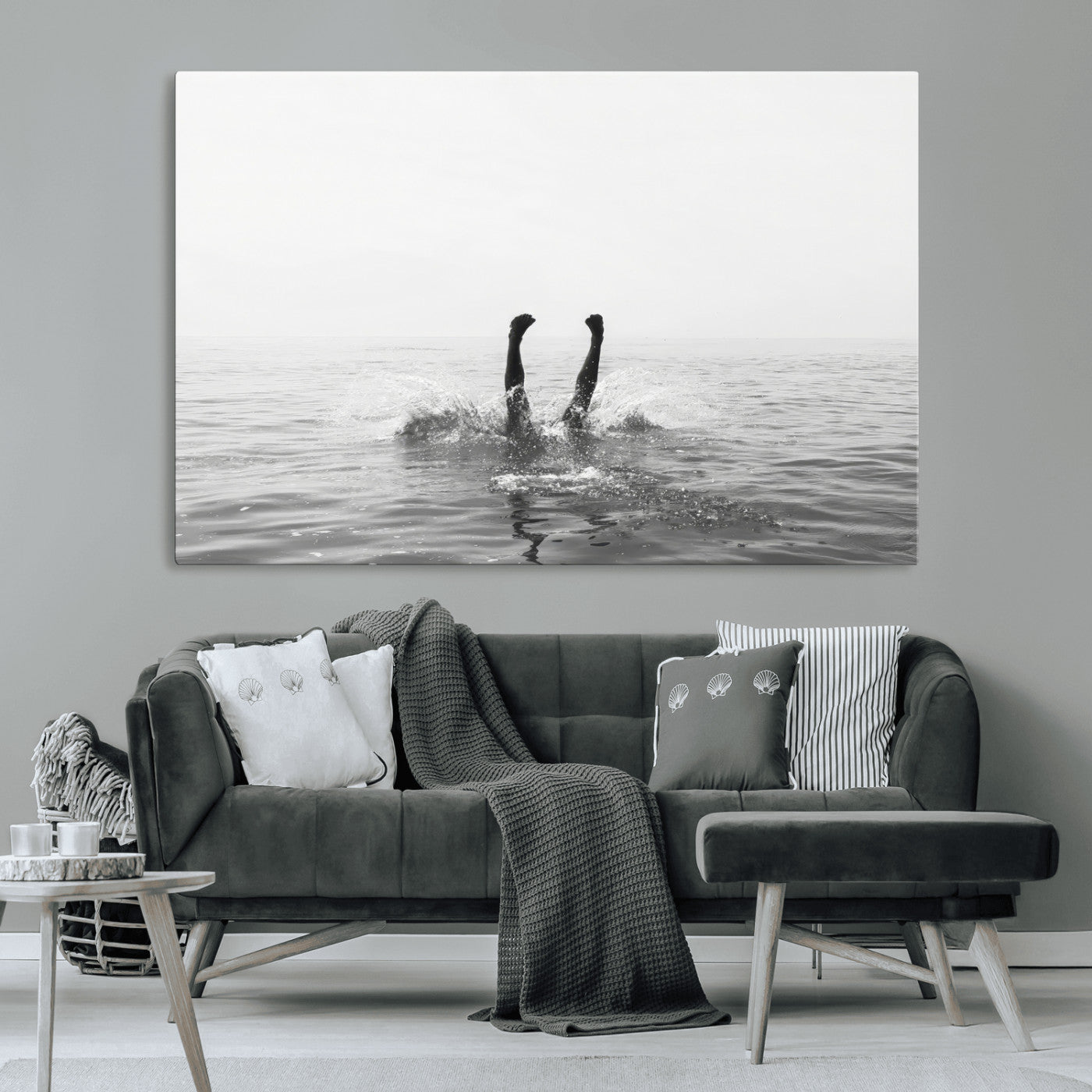 A black and white minimalist water scene capturing a playful splash as a swimmer dives upside down, creating a carefree and artistic aquatic aesthetic.