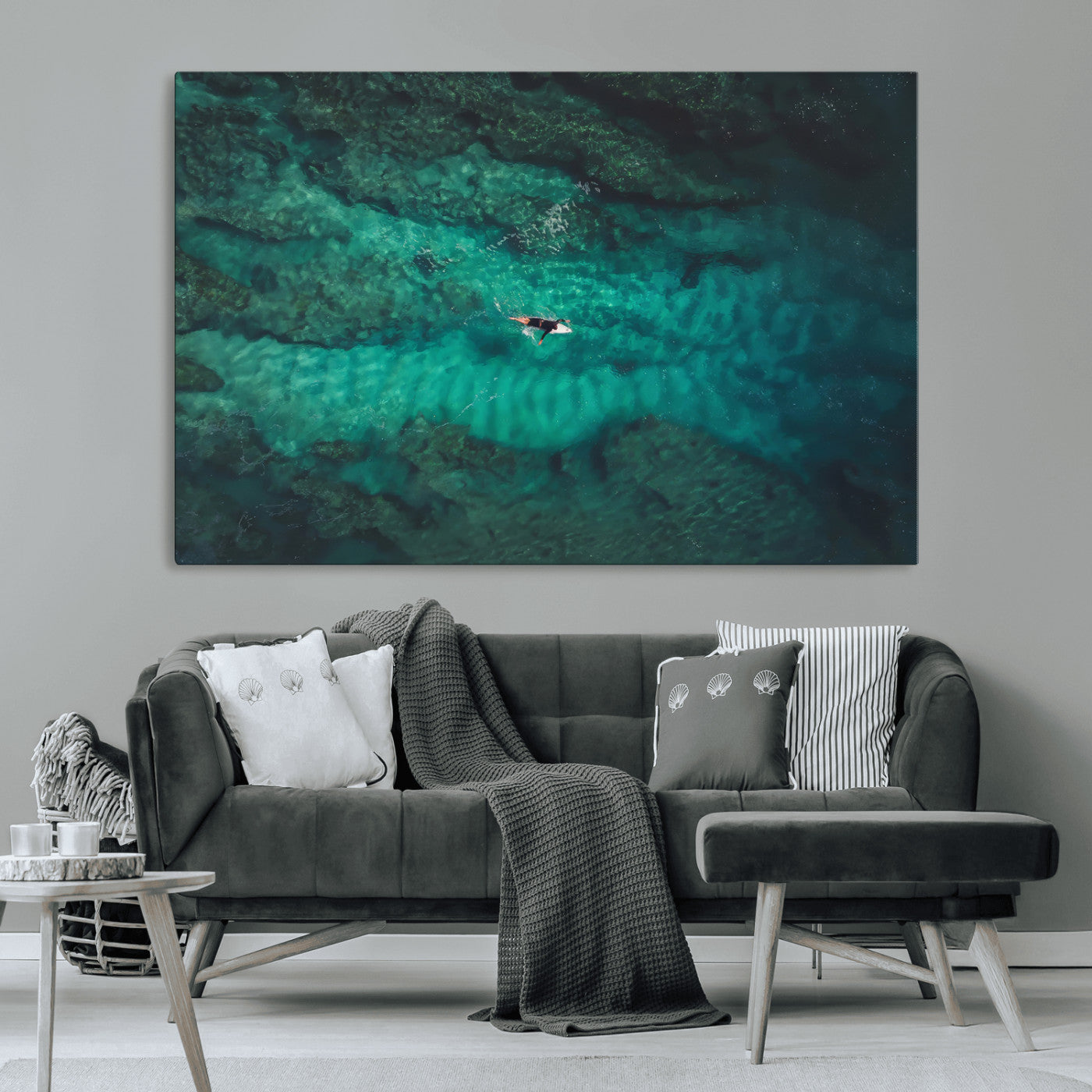 An aerial view of a solo surfer paddling through crystal-clear turquoise waters over a sunlit reef, capturing the beauty and serenity of open water surfing.
