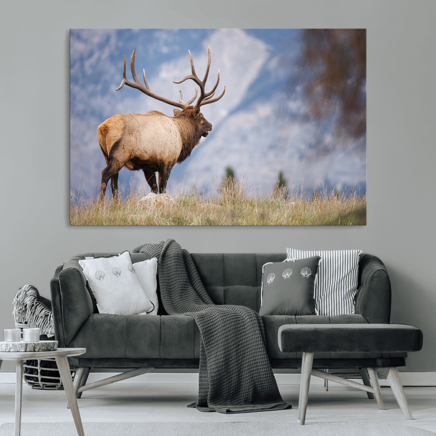 Elk with antlers standing on grass with mountain background, ideal for rustic, cabin, or lodge-inspired wall decor.