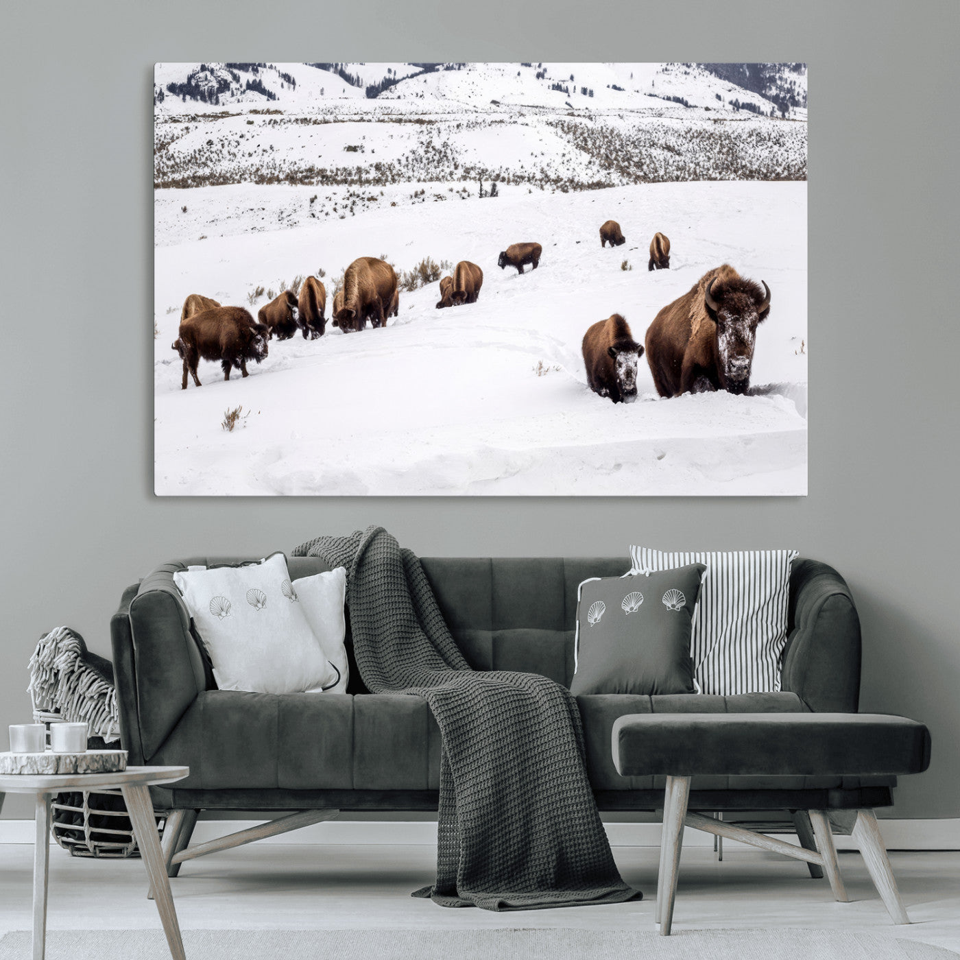 A herd of bison walking through deep snow in a mountain valley, perfect for rustic, cabin or western-themed wall decor.