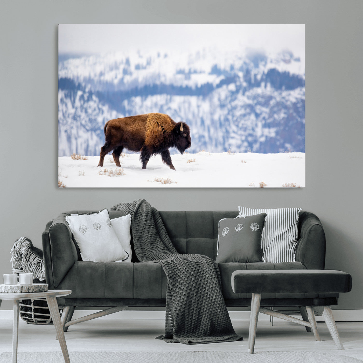 A lone bison walks across snowy ground with blue-toned mountain range behind, ideal for rustic or western farmhouse interiors.