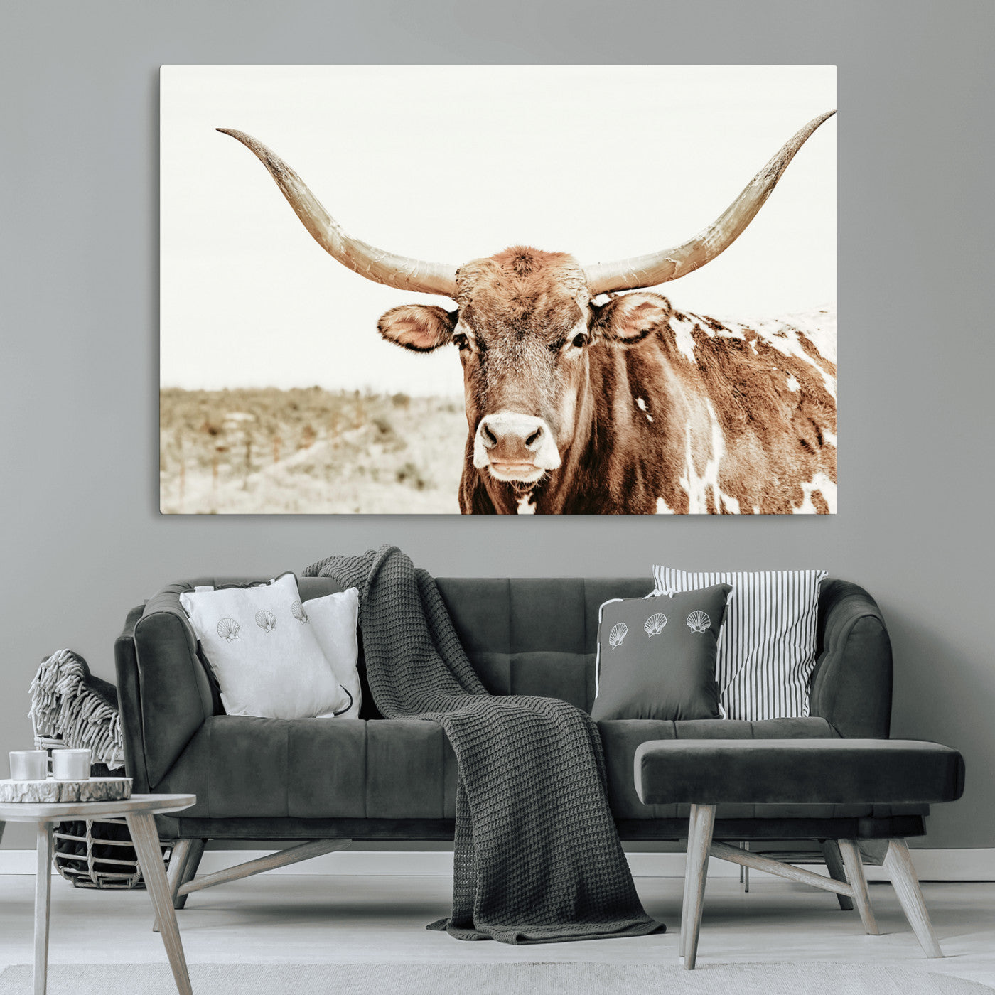 A Texas longhorn bull with wide horns, standing in a dry field under soft light, ideal for rustic farmhouse or western-themed interiors.