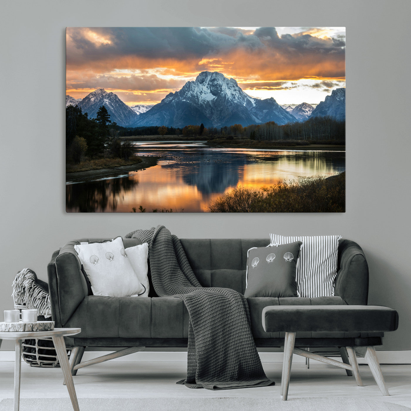 Snow-capped mountains reflecting in a calm lake at sunset, with a dramatic golden sky creating a breathtaking wilderness scene.