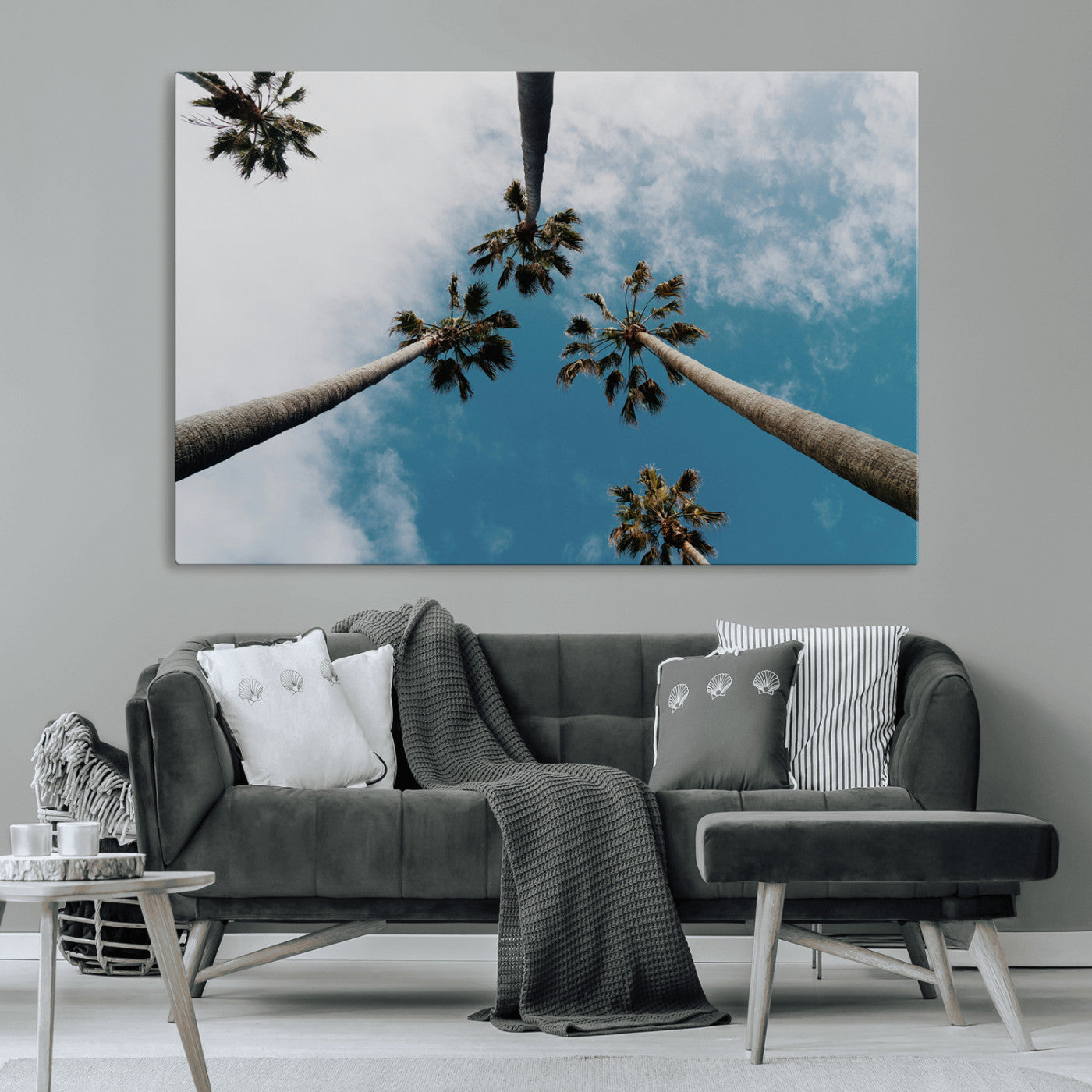 Looking up at tall palm trees against a bright blue sky with scattered clouds, creating a tropical and airy atmosphere for modern home decor.