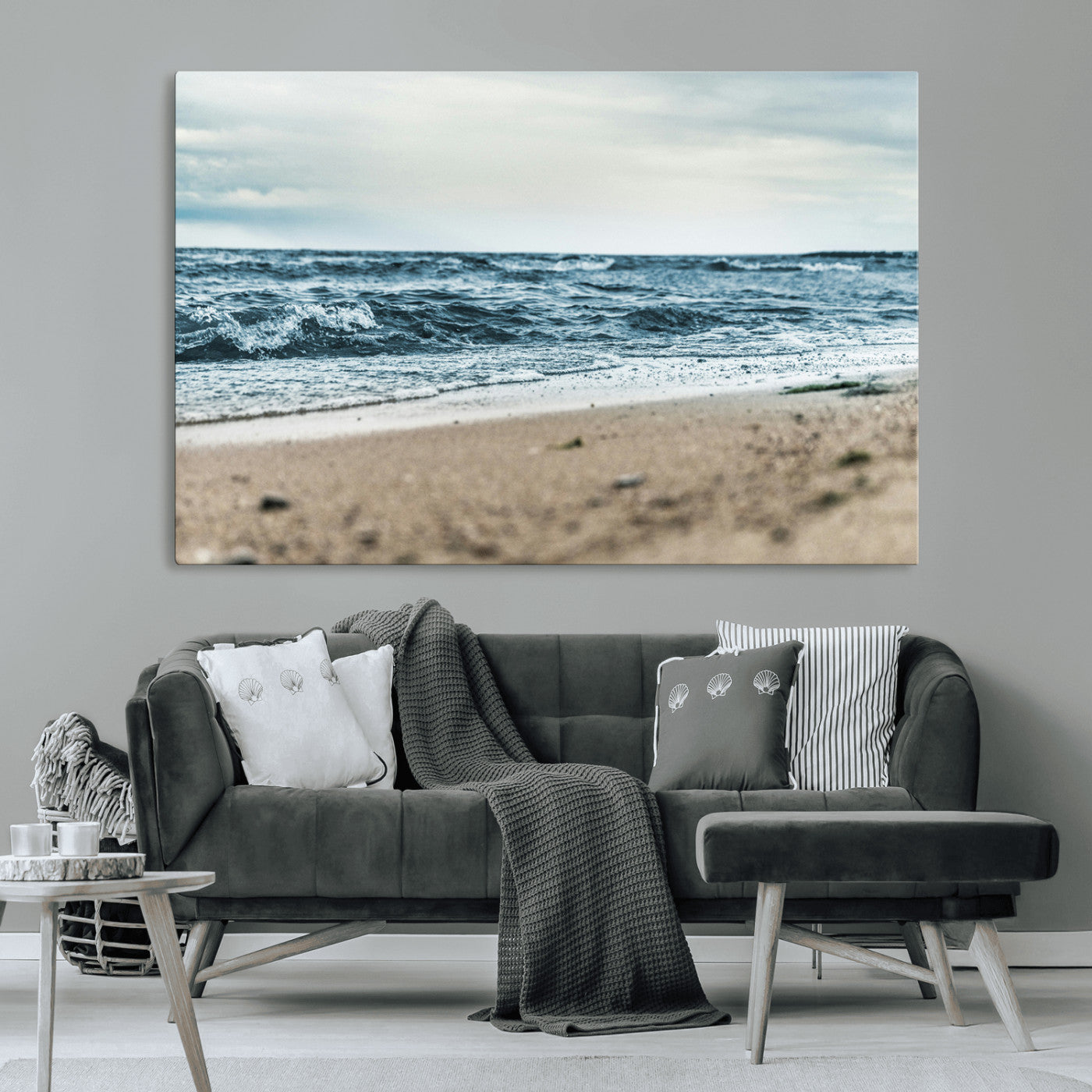 A moody ocean scene with gentle waves washing onto a sandy beach under a cloudy sky, creating a peaceful and coastal atmosphere.