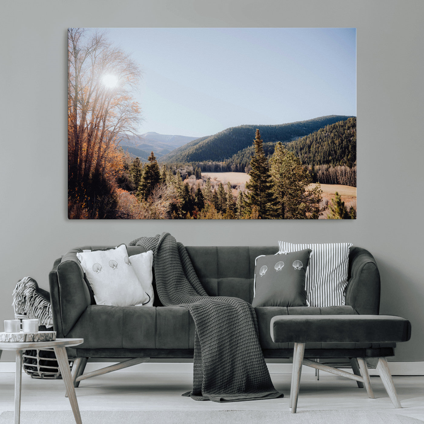 A scenic mountain valley with pine trees and autumn foliage under a clear sky, bathed in golden sunlight, creating a peaceful and rustic landscape.