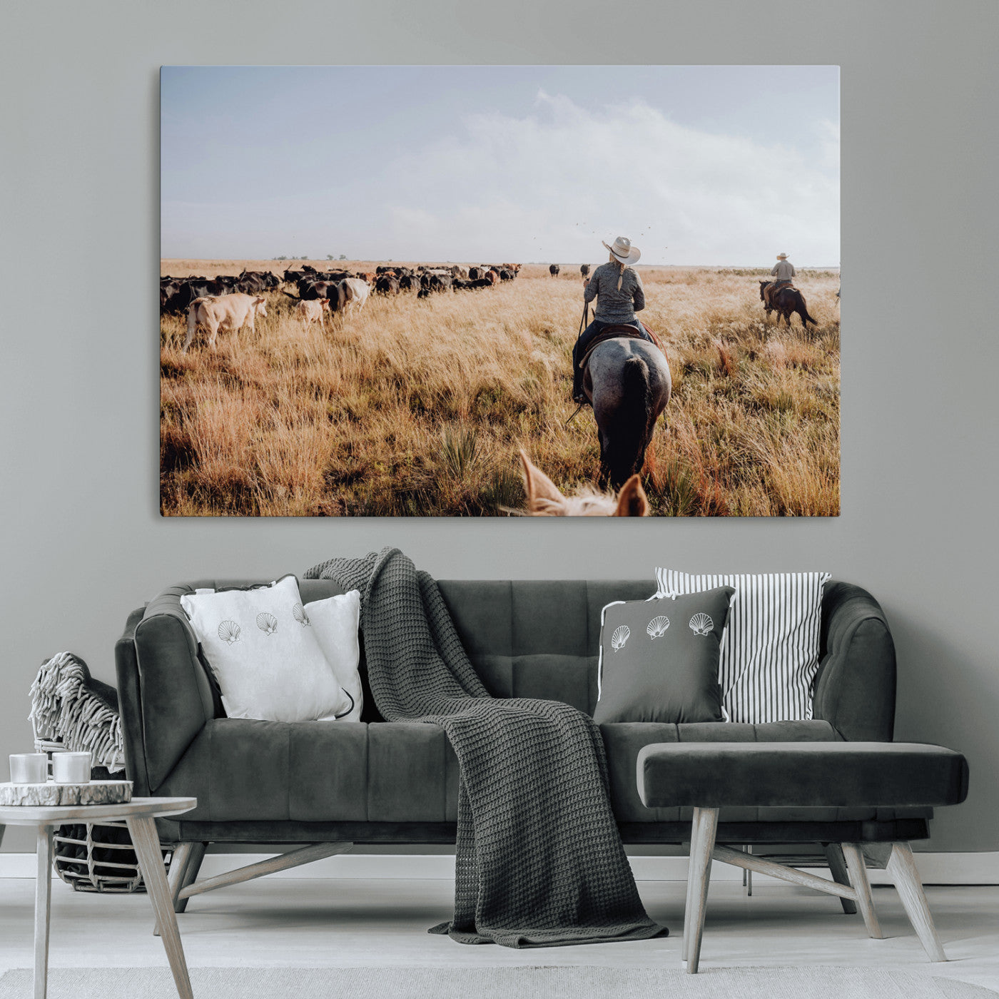 A cowboy and cowgirl on horseback herding cattle through golden grasslands, capturing a rustic and authentic Western ranch lifestyle.