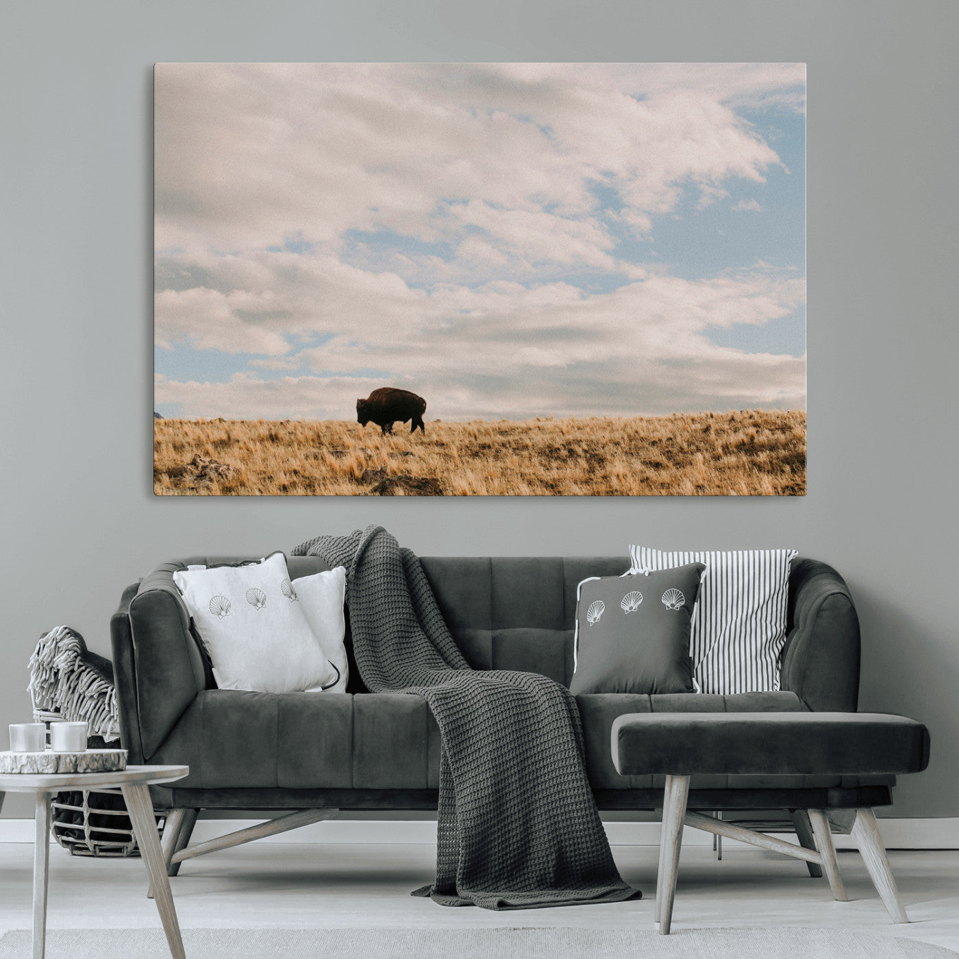 A solitary bison walking across a golden prairie under a vast, cloud-filled sky, evoking a peaceful, rustic western landscape for home decor.