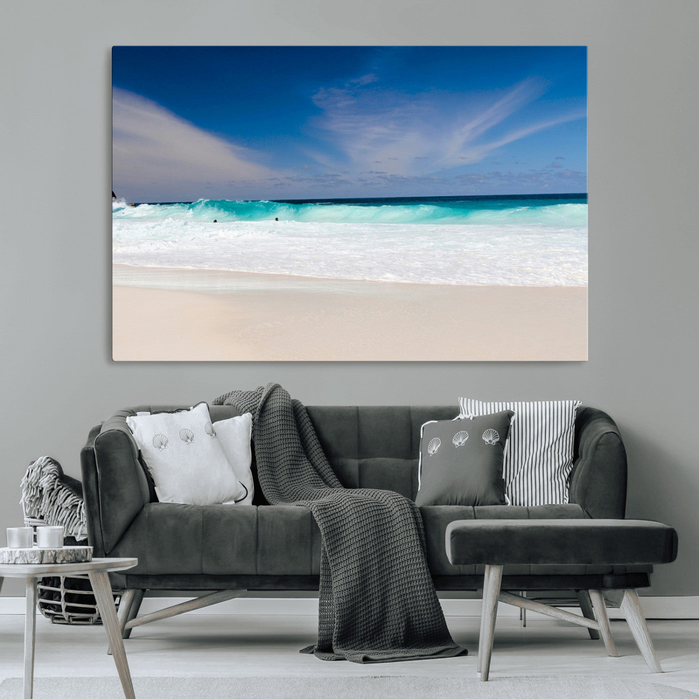 Turquoise waves crash onto a pristine white sand beach under a vivid blue sky with wispy clouds, creating a peaceful and refreshing coastal scene.