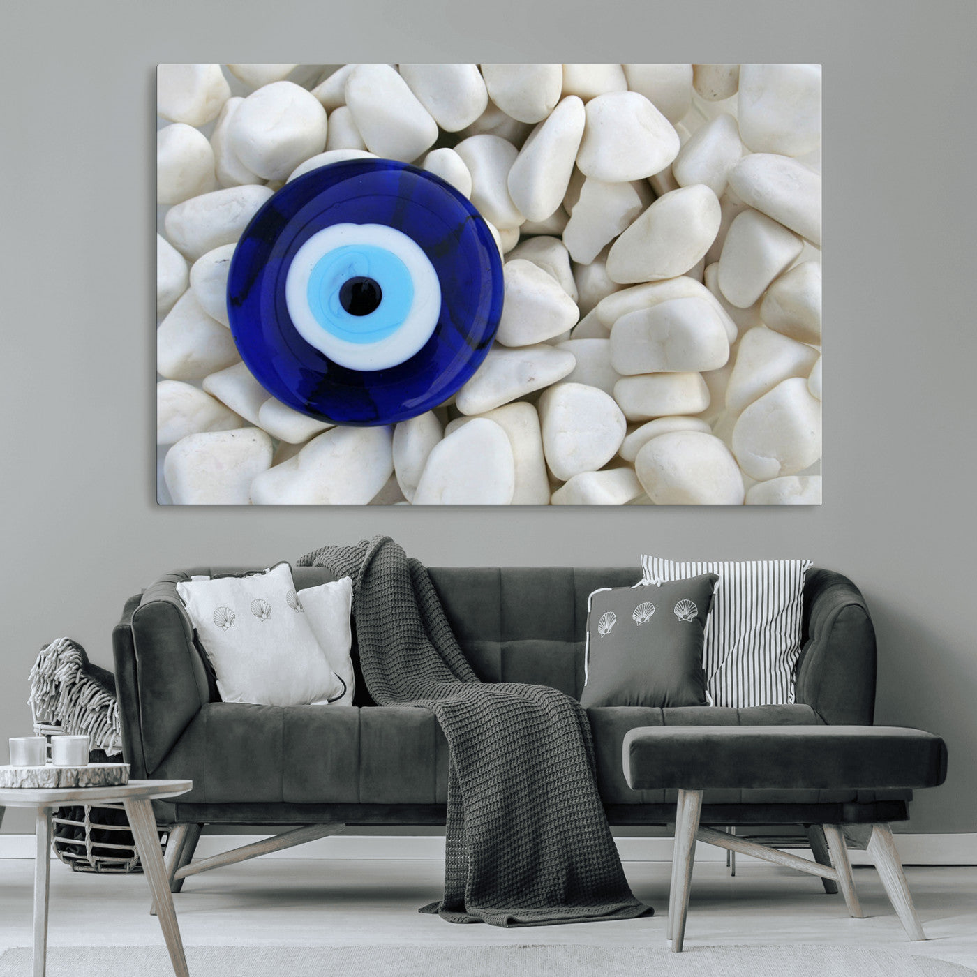 A close-up of a blue evil eye charm placed on white pebbles, symbolizing protection and good luck.