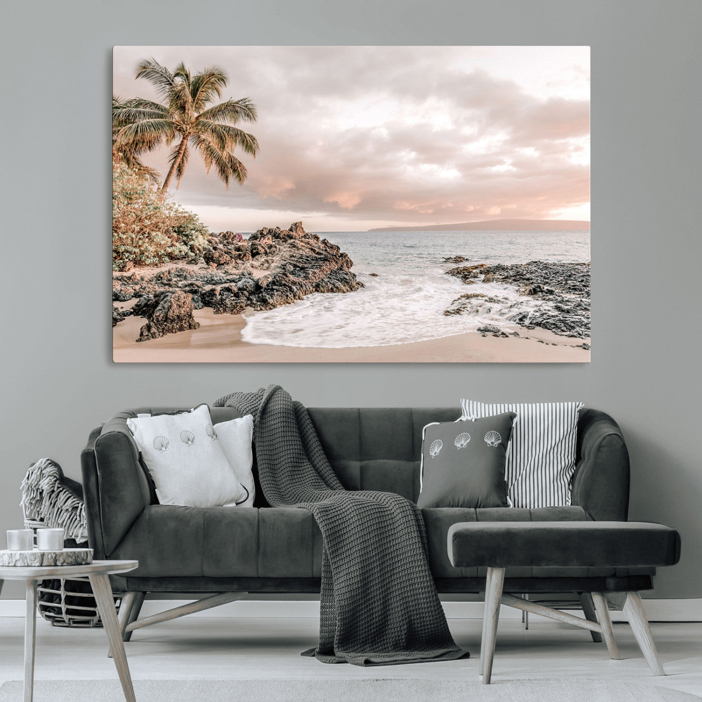A peaceful beach scene with a palm tree and rocks, soft waves washing onto the shore under a soft pastel sky at sunset.
