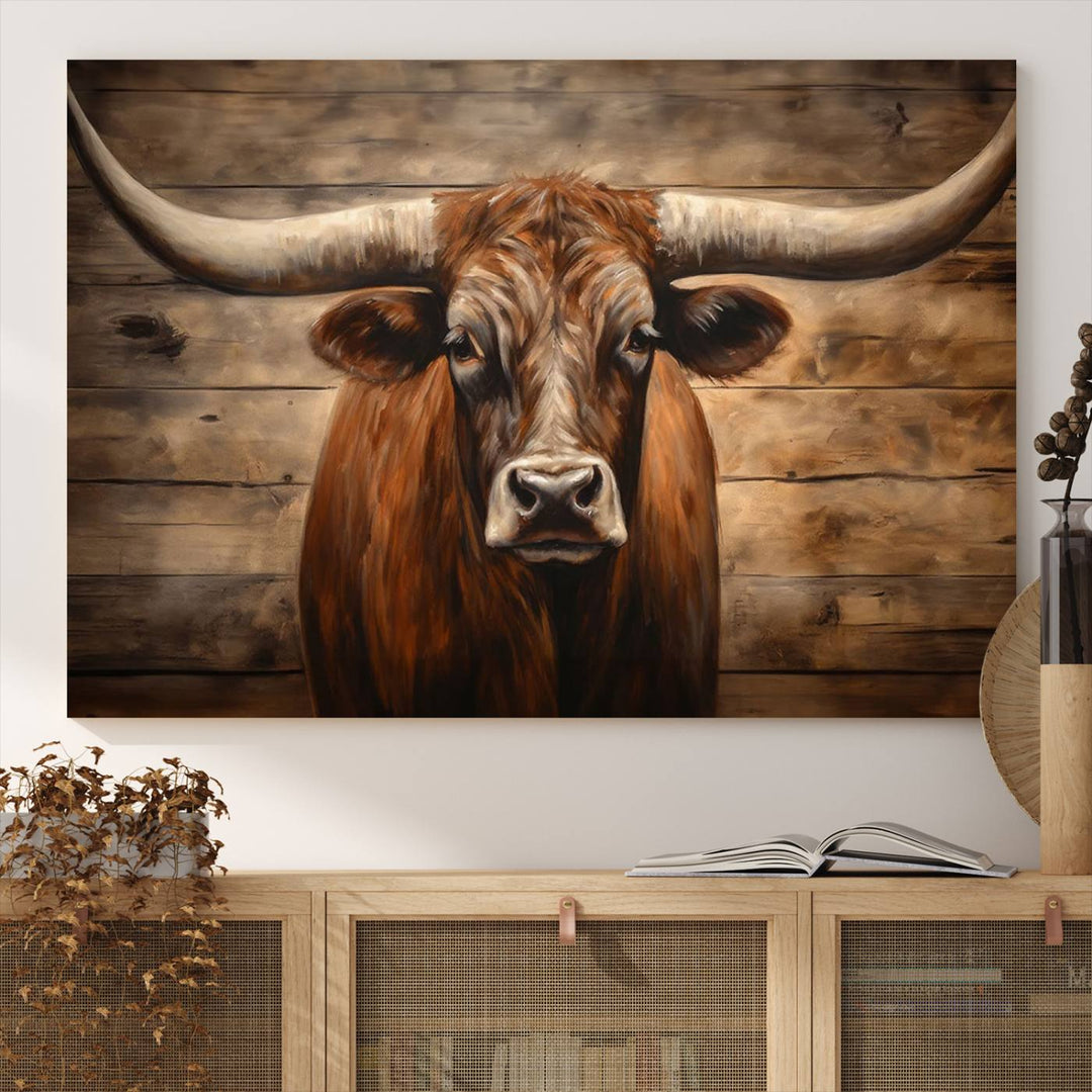 The Longhorn Bull Wall Art, a ready-to-hang canvas print, showcases an image of a brown longhorn cow set against a wooden background, perfect for those looking to enhance their space with rustic farmhouse and western barn decor.