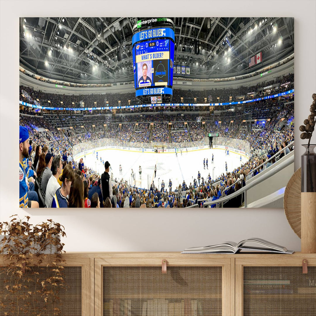 Wall art prints depicting the bustling scenes of the St. Louis Blues being cheered on by a full house at the Enterprise Center, beneath a large scoreboard.