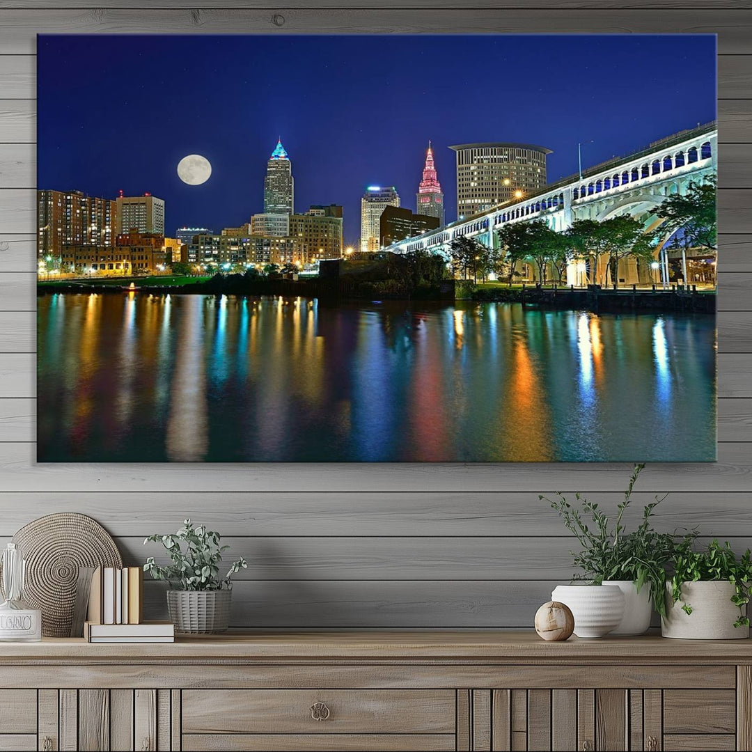 Cleveland City Lights Night Skyline Wall Art canvas showcases a moonlit cityscape reflected on water.