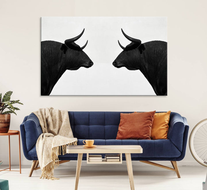 A framed canvas print featuring two black bull silhouettes, perfect for modern rustic decor.