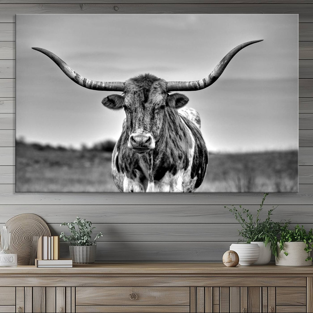 The Texas Longhorn Cow wall art, divided into three panels, is of gallery quality and displayed on a dark wall.