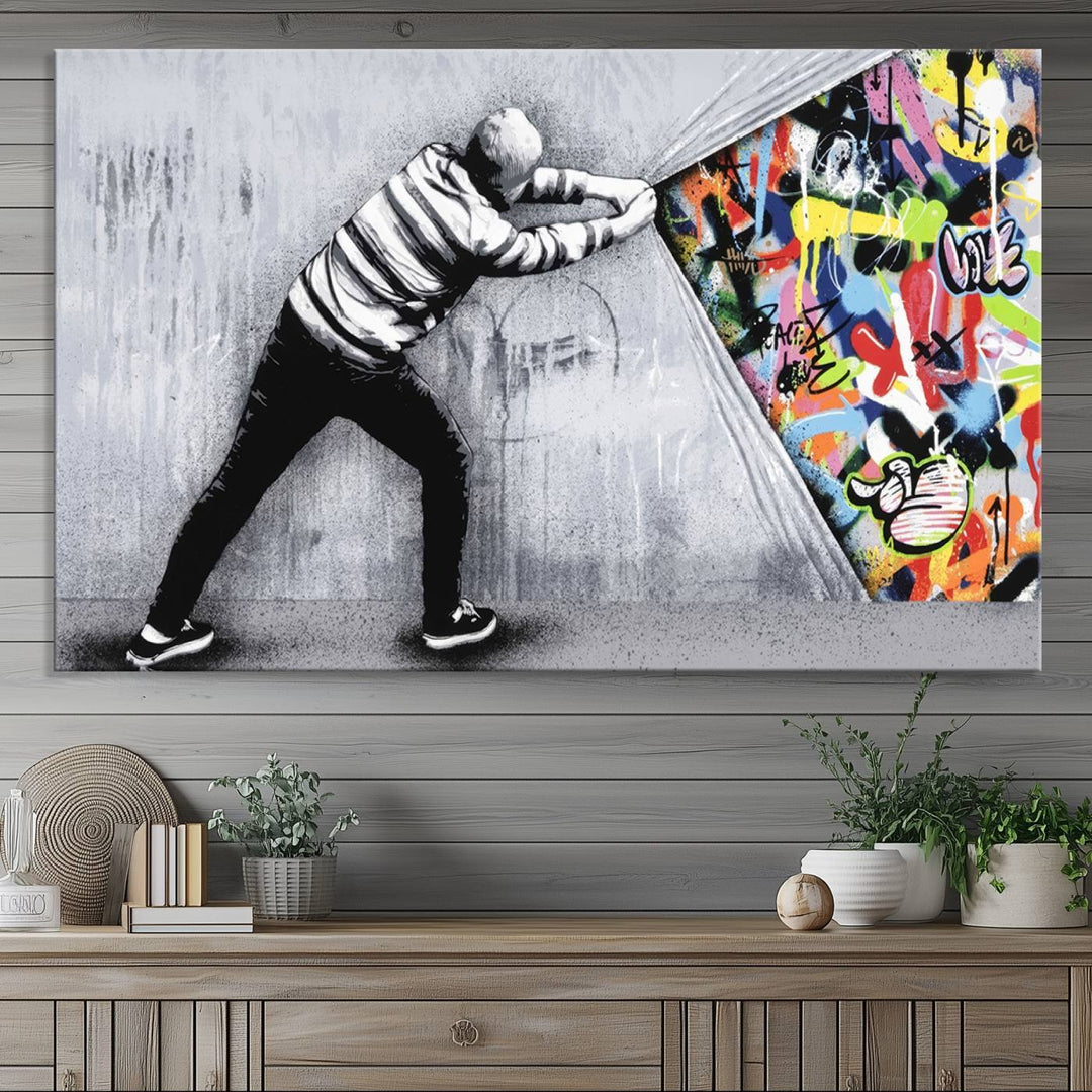 A 3-panel print of Banksys Art Behind the Curtain reveals colorful graffiti beneath a peeling wall.