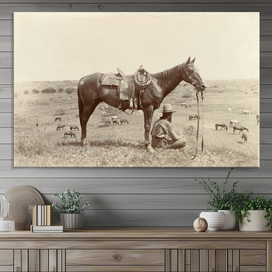 Cowboy Wall Art - Vintage Western Horse Canvas Print features a cowboy kneeling by his horse in a field.