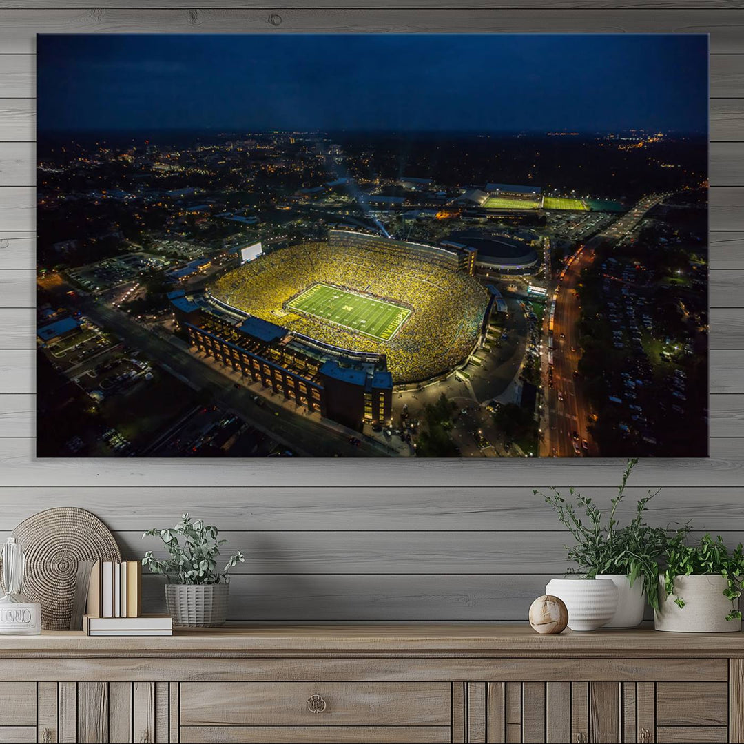 Aerial view of Michigan Stadium at night, surrounded by city lights, depicted on a Michigan Wolverines wall art canvas print.