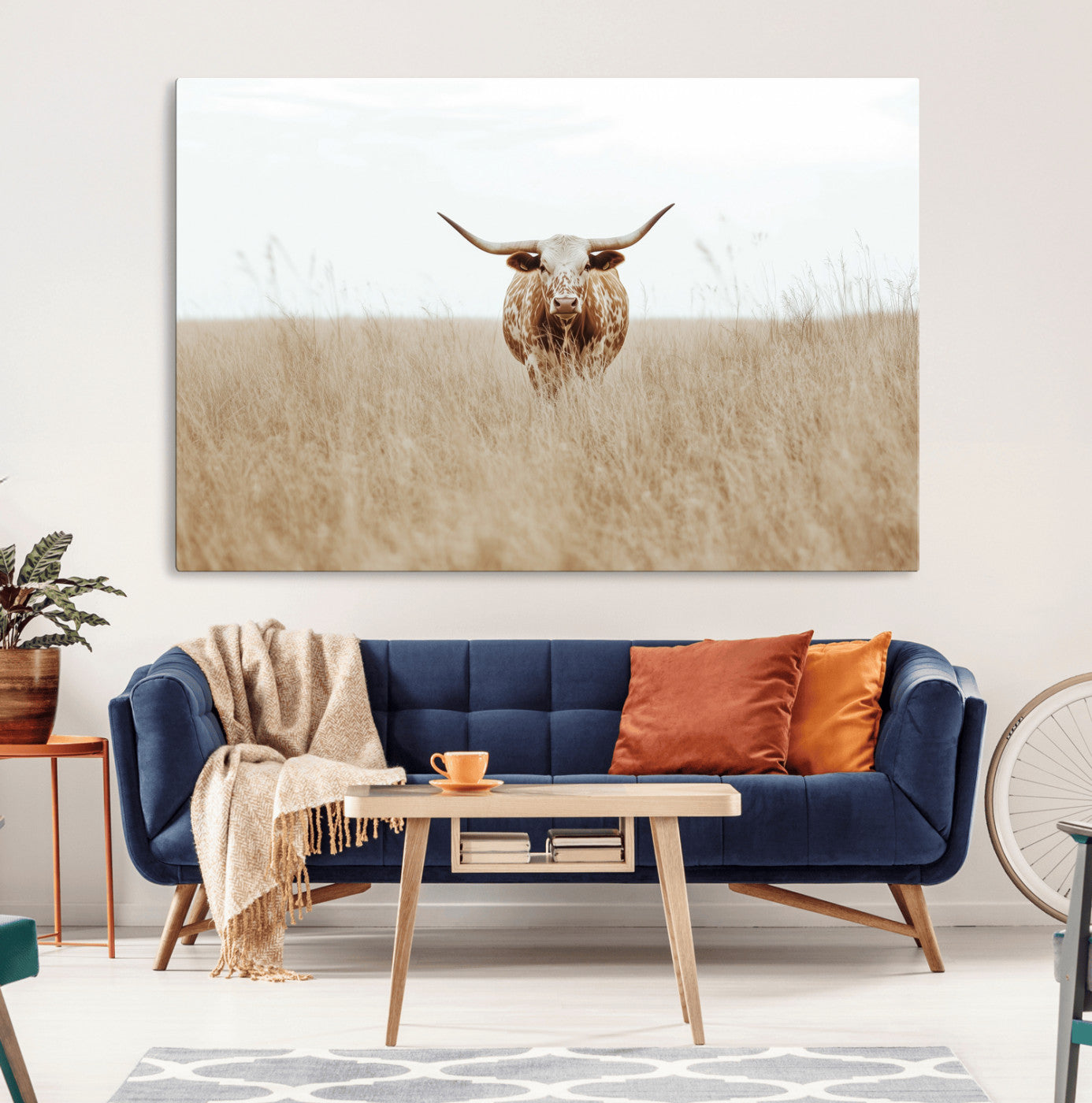 Texas Longhorn bull standing alone in dry grass with neutral tones, ideal for rustic western or cowboy-themed wall decor.