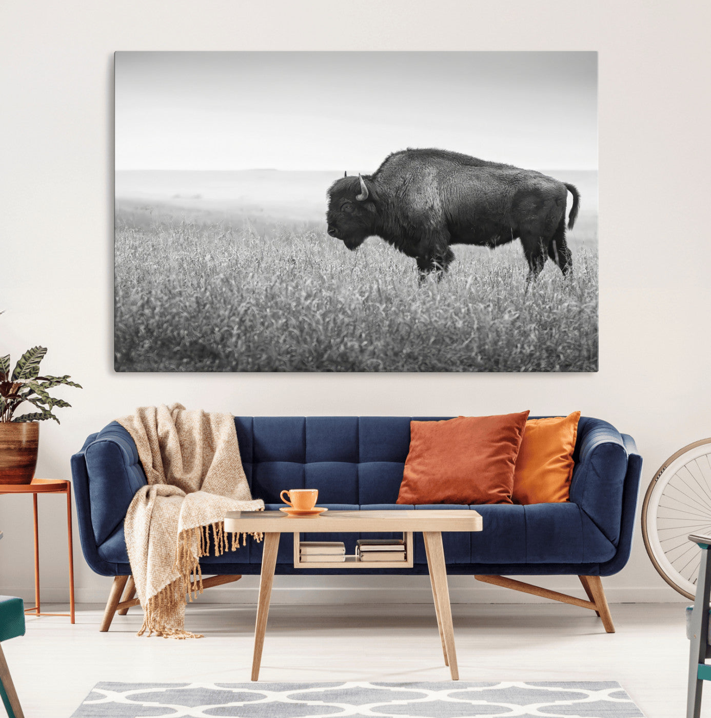 A black and white photograph of a majestic bison standing in a vast grassy prairie, evoking a sense of wilderness and strength.