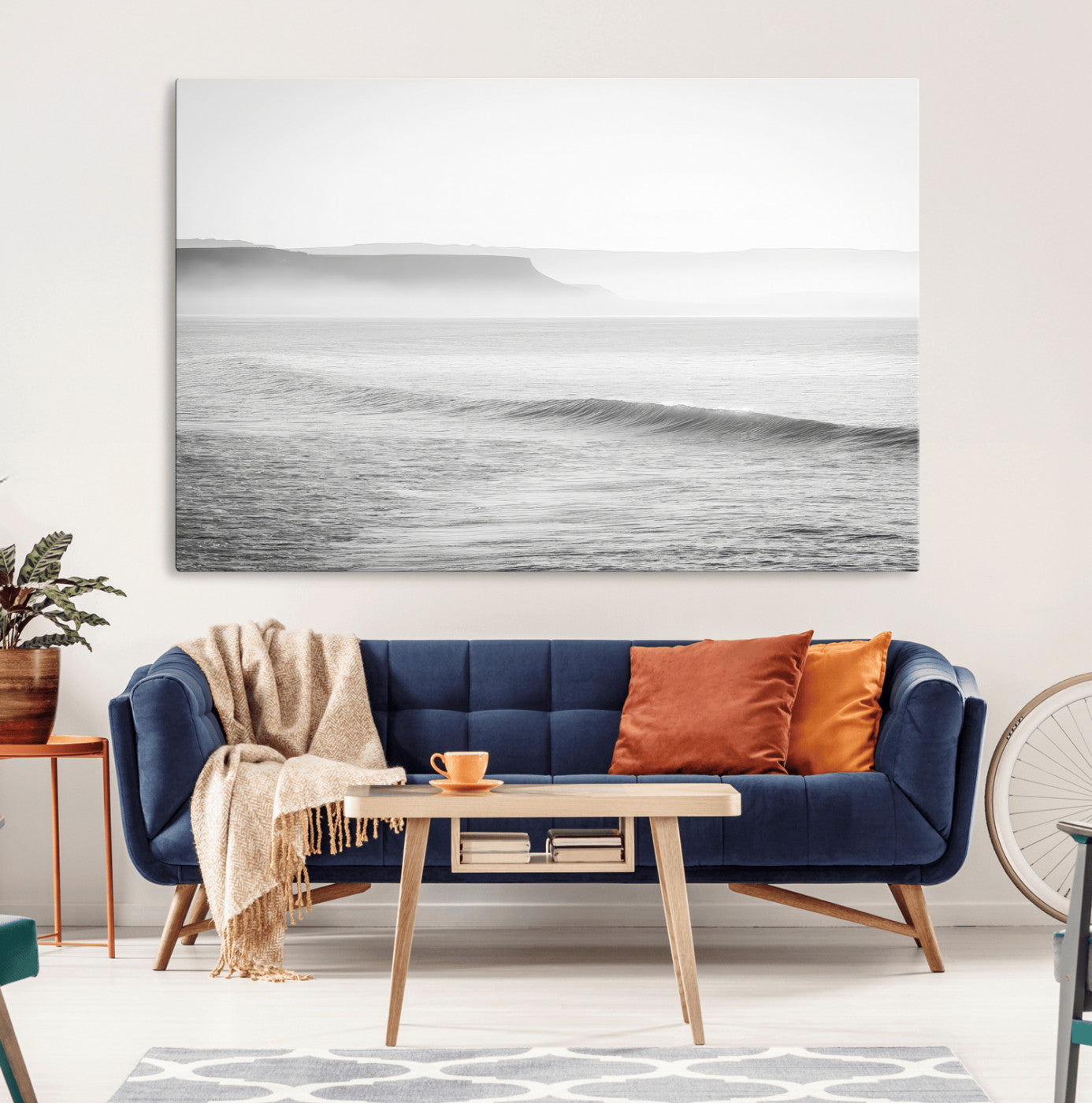 A black and white minimalist seascape featuring soft rolling waves and misty distant cliffs, creating a serene and timeless coastal atmosphere.