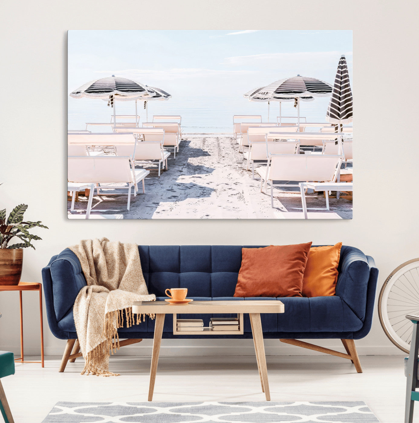 A serene minimalist beach scene featuring striped umbrellas, soft pastel sand, and an elegant lounge setup, creating a tranquil and stylish coastal retreat.