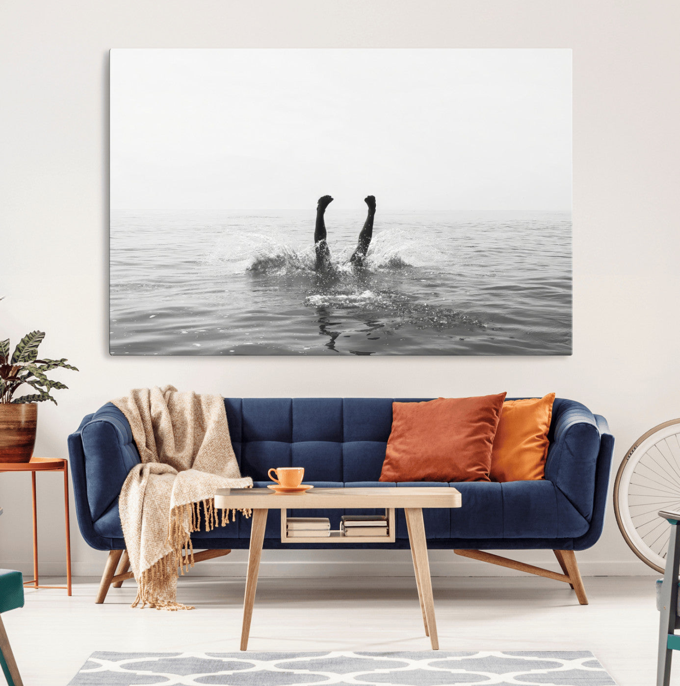 A black and white minimalist water scene capturing a playful splash as a swimmer dives upside down, creating a carefree and artistic aquatic aesthetic.