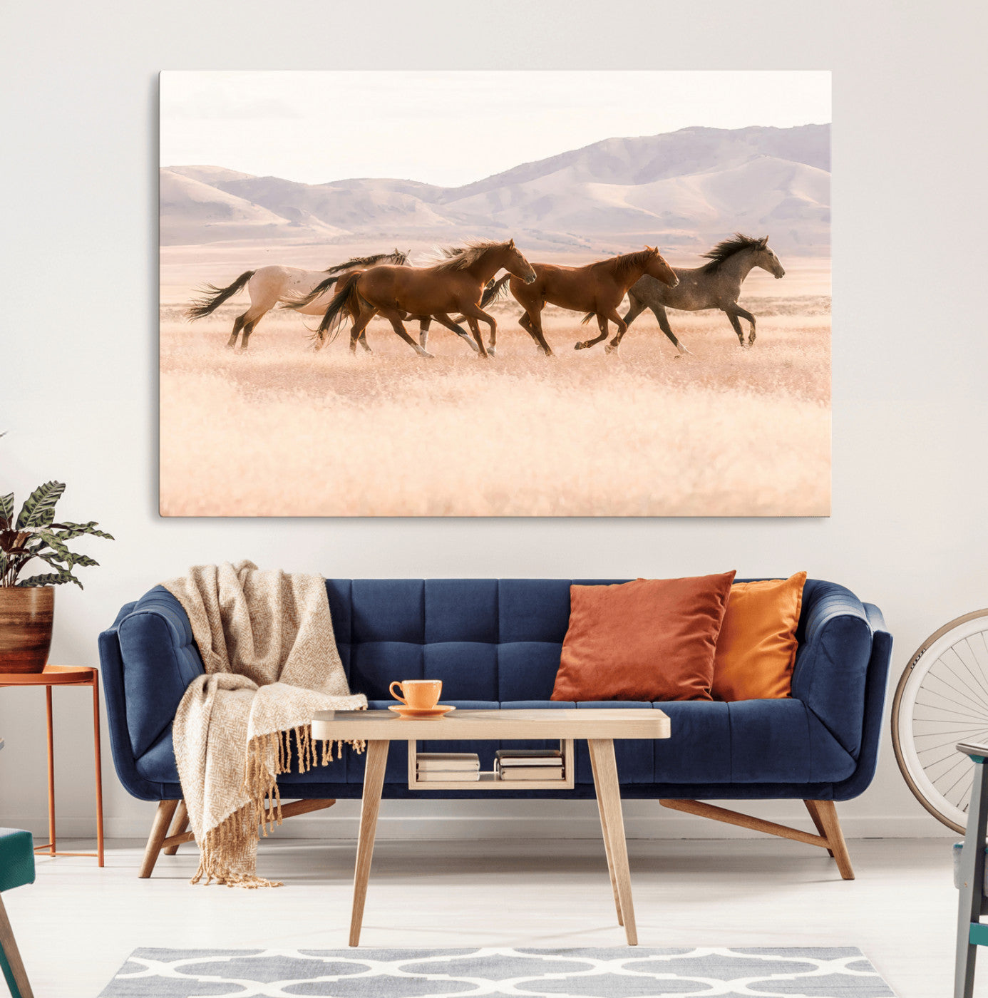 A herd of wild horses galloping through a sunlit desert plain with mountains in the background, perfect for rustic or western-themed wall decor.