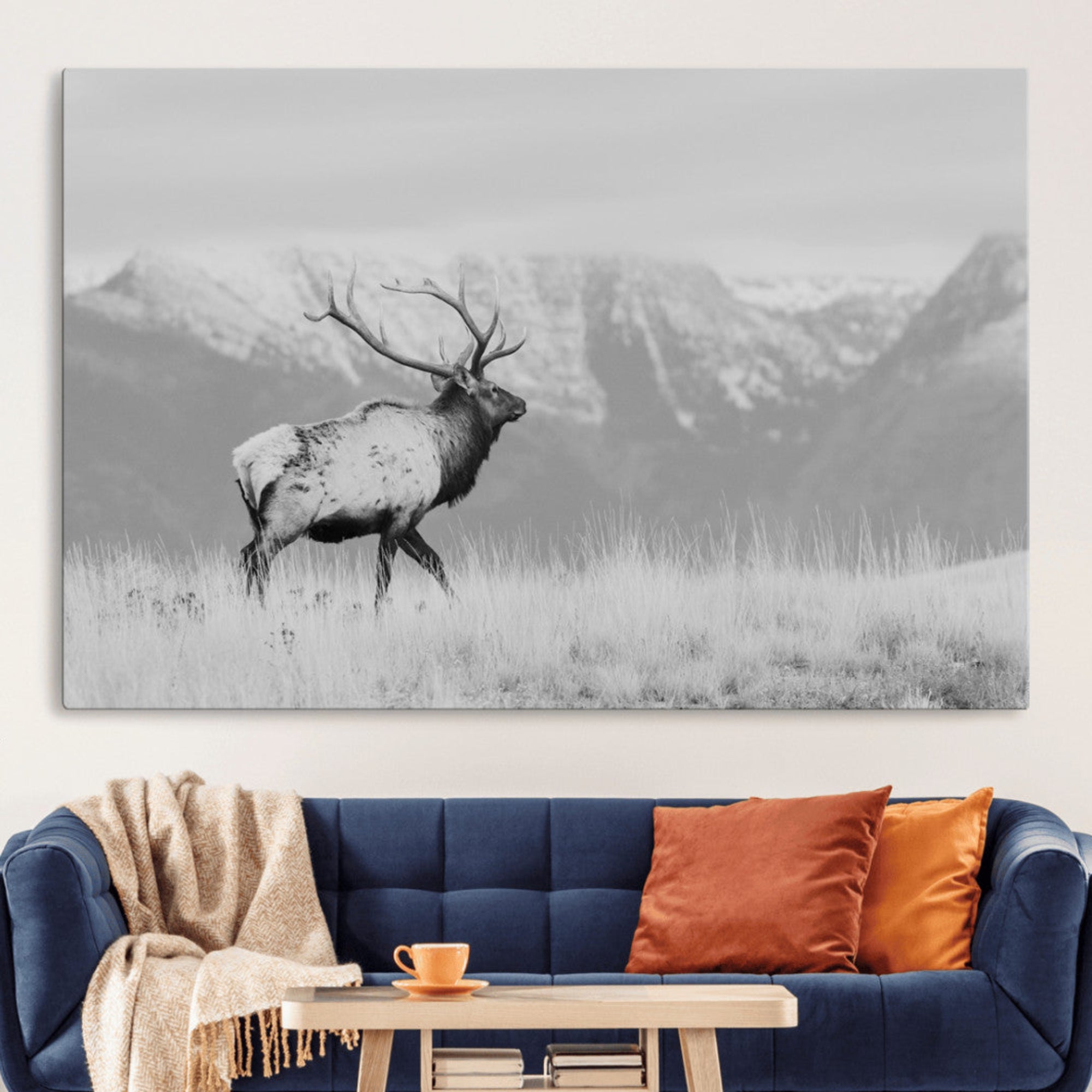Black and white elk with antlers walking in a field, snowy mountain backdrop, ideal for rustic lodge or minimalist wall decor.