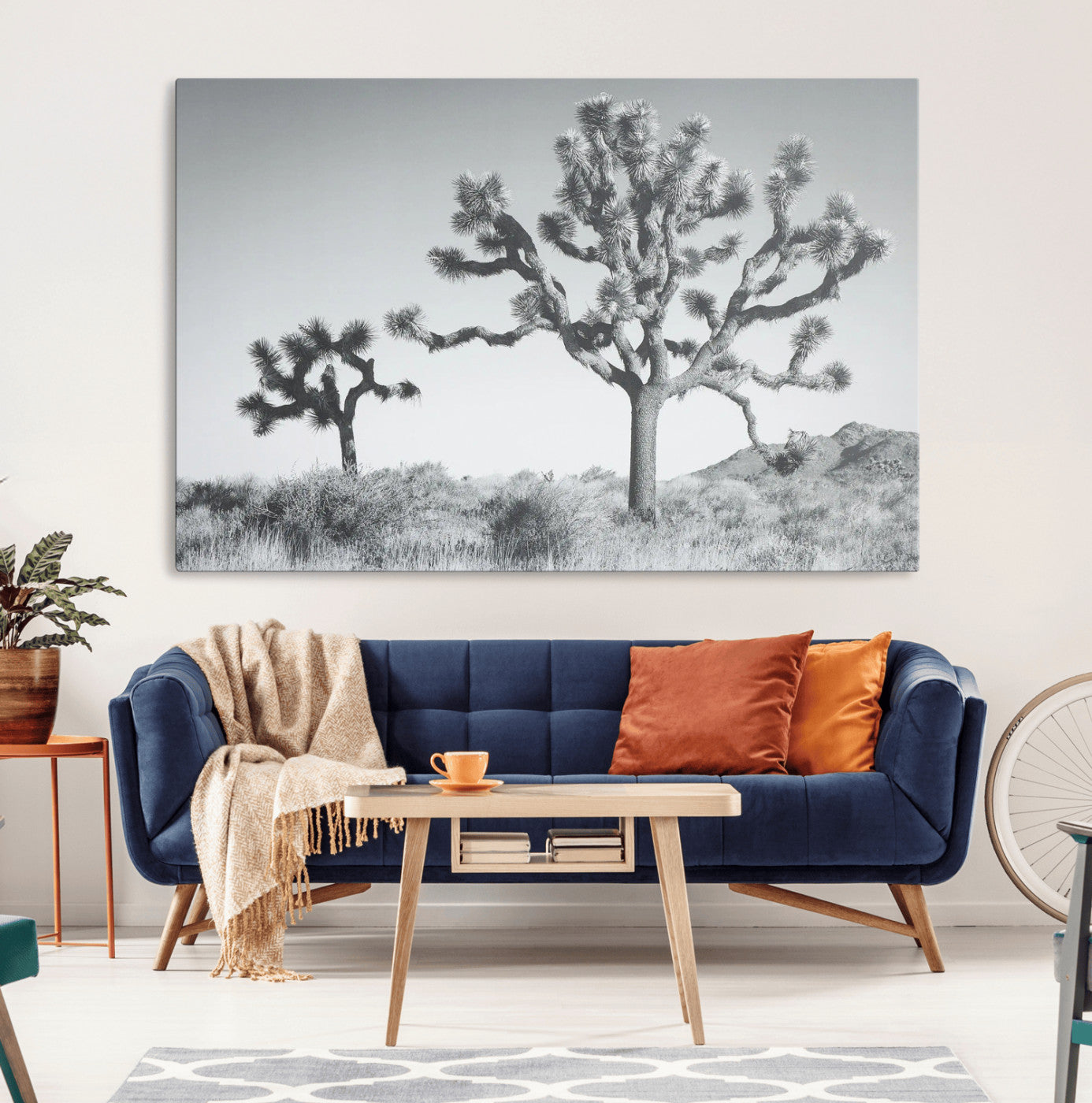 Two Joshua trees in a black and white desert landscape with distant hills, ideal for boho or rustic interior wall styling.