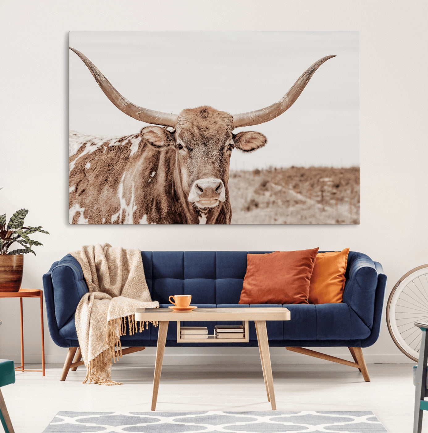 A longhorn cow in soft beige desert tones, standing calmly in open land, perfect for neutral western or rustic farmhouse interiors.