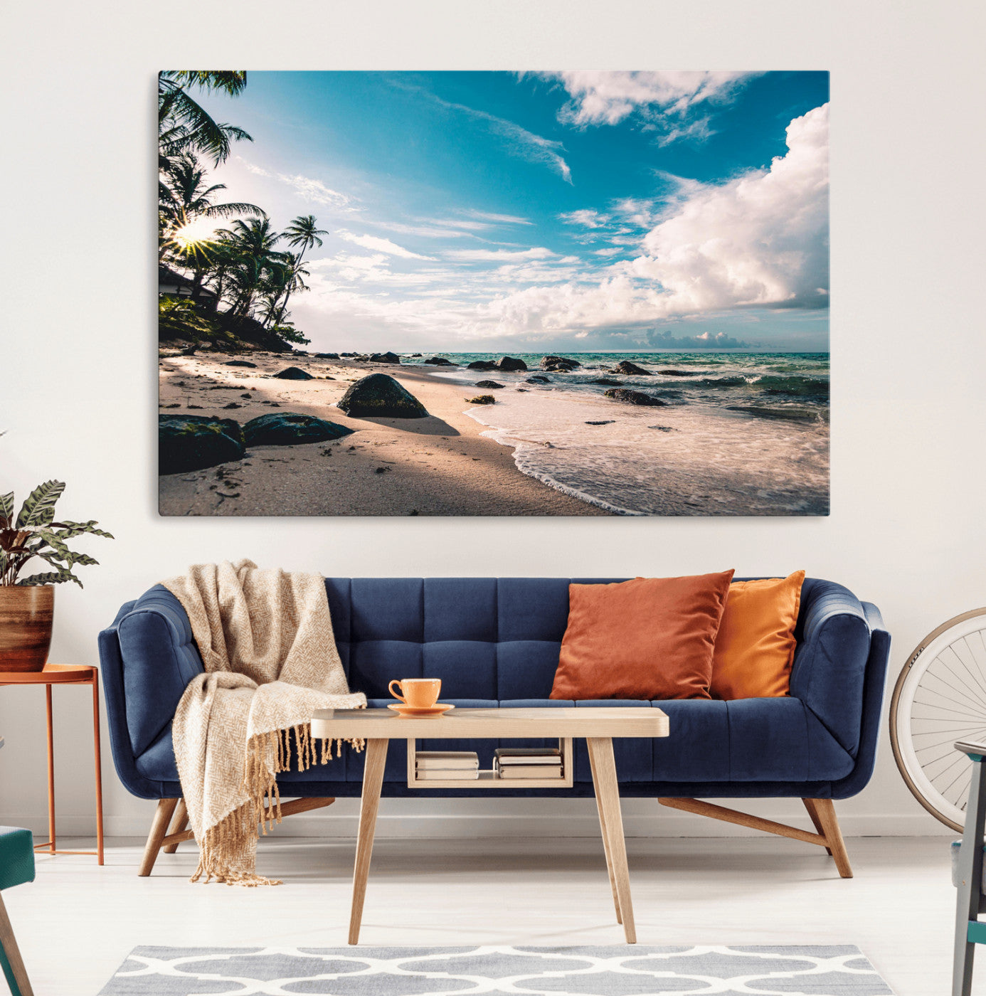 Scenic tropical beach with palm trees, ocean waves, and rocky shoreline under a bright blue sky, creating a serene coastal vibe.