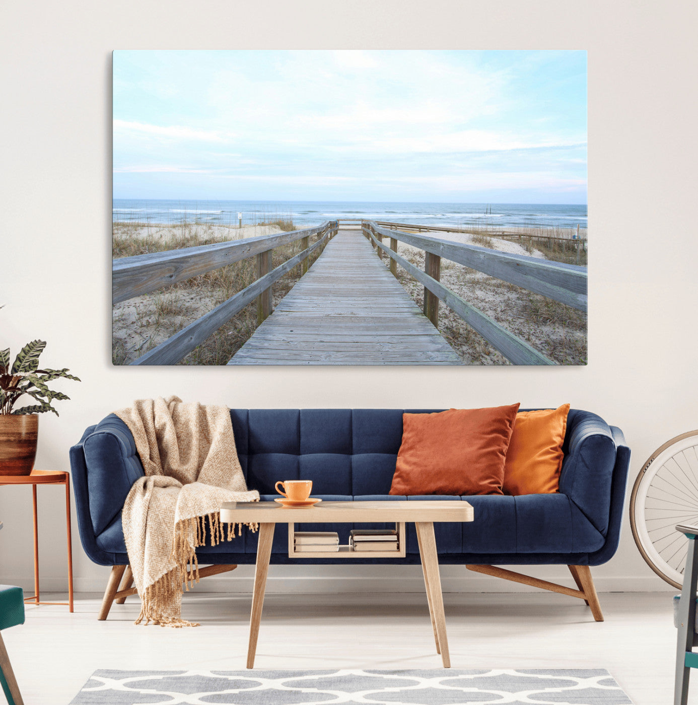 Wooden boardwalk leading to a peaceful beach with gentle ocean waves under a soft pastel sky, perfect for coastal and nautical home decor.