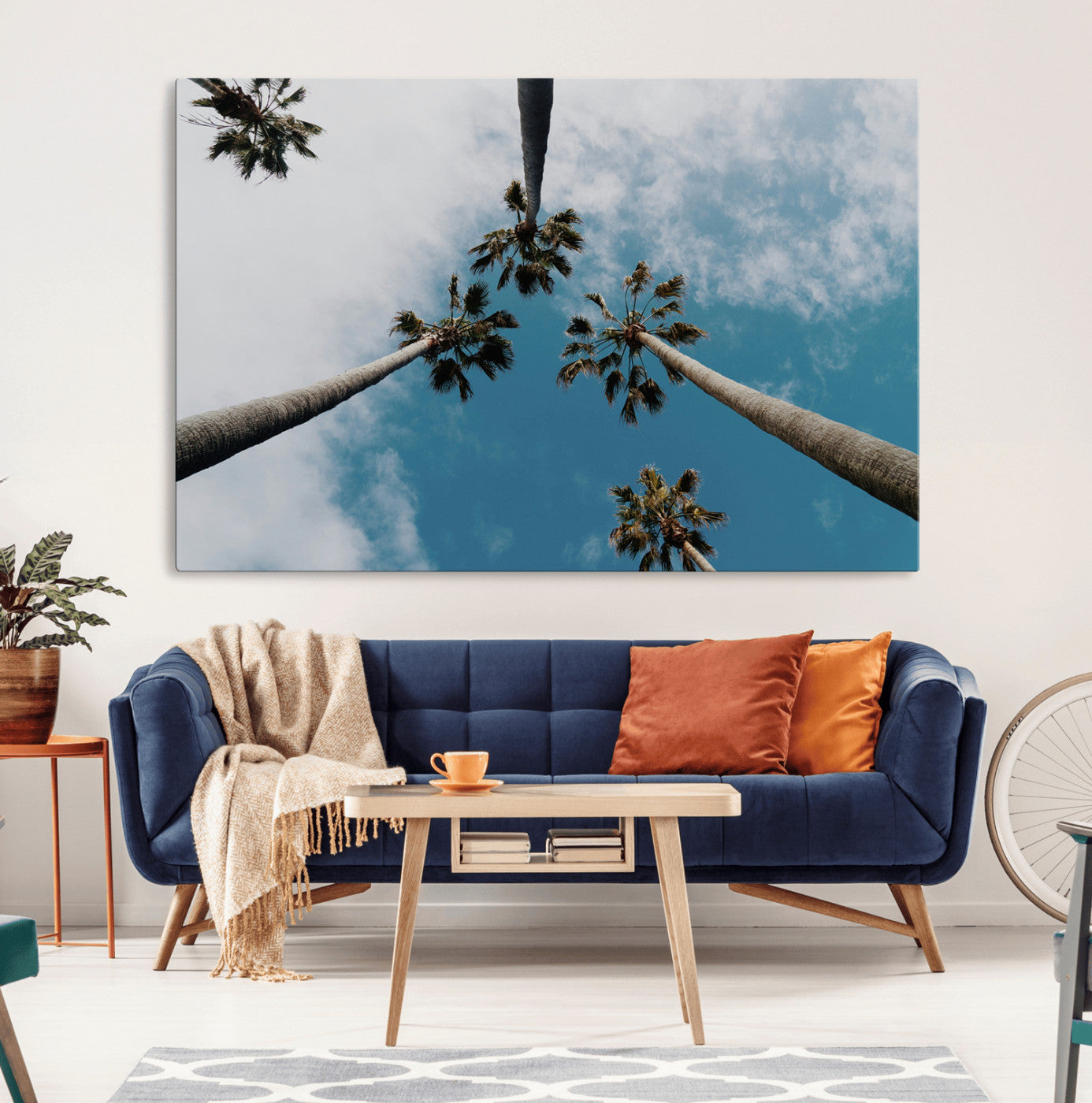 Looking up at tall palm trees against a bright blue sky with scattered clouds, creating a tropical and airy atmosphere for modern home decor.
