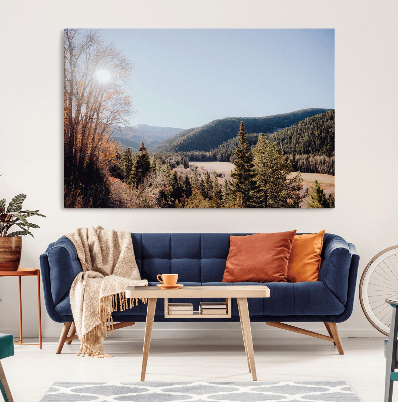 A scenic mountain valley with pine trees and autumn foliage under a clear sky, bathed in golden sunlight, creating a peaceful and rustic landscape.
