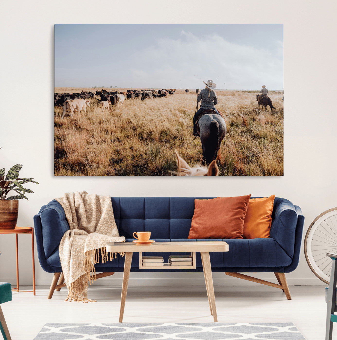A cowboy and cowgirl on horseback herding cattle through golden grasslands, capturing a rustic and authentic Western ranch lifestyle.