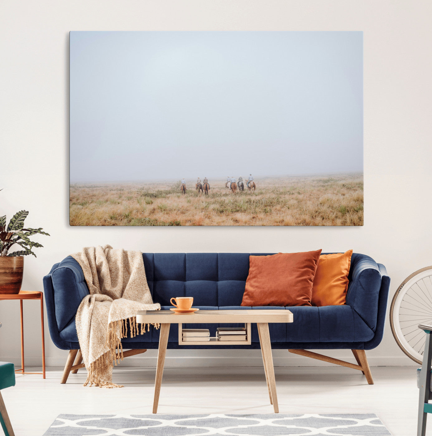 A group of horseback riders moving through a fog-shrouded field, evoking a calm Western scene with golden grasses and soft horizons.