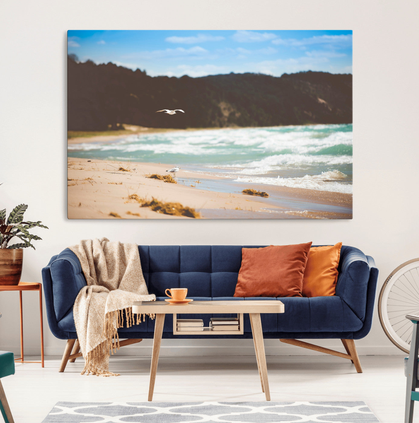 Serene beach scene with gentle ocean waves, sandy shore, and a seagull flying under a blue sky, perfect for coastal and nature-inspired decor.