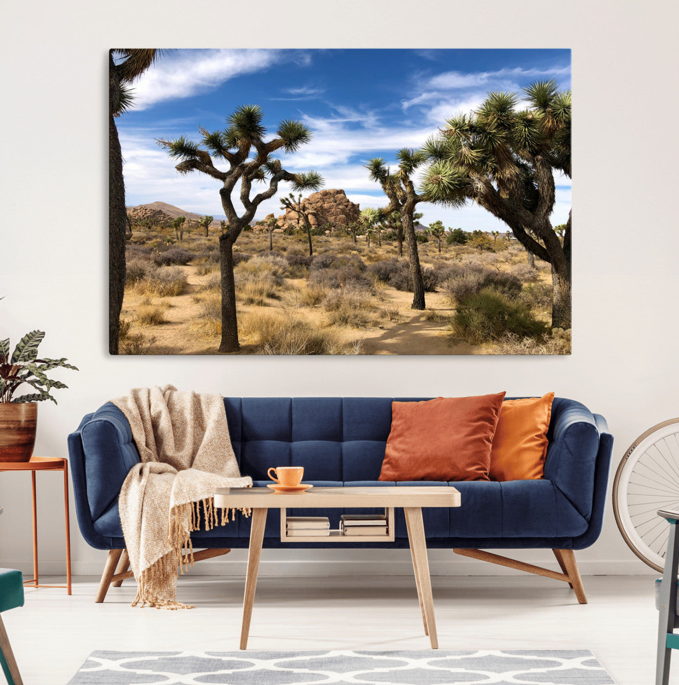 Scenic Joshua Tree landscape with rugged desert terrain, golden dry grass, and a deep blue sky, creating a warm, rustic Southwestern aesthetic.