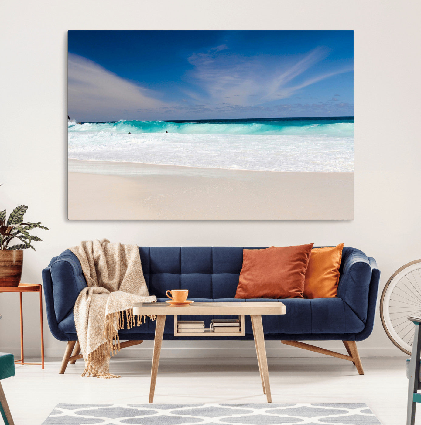 Turquoise waves crash onto a pristine white sand beach under a vivid blue sky with wispy clouds, creating a peaceful and refreshing coastal scene.