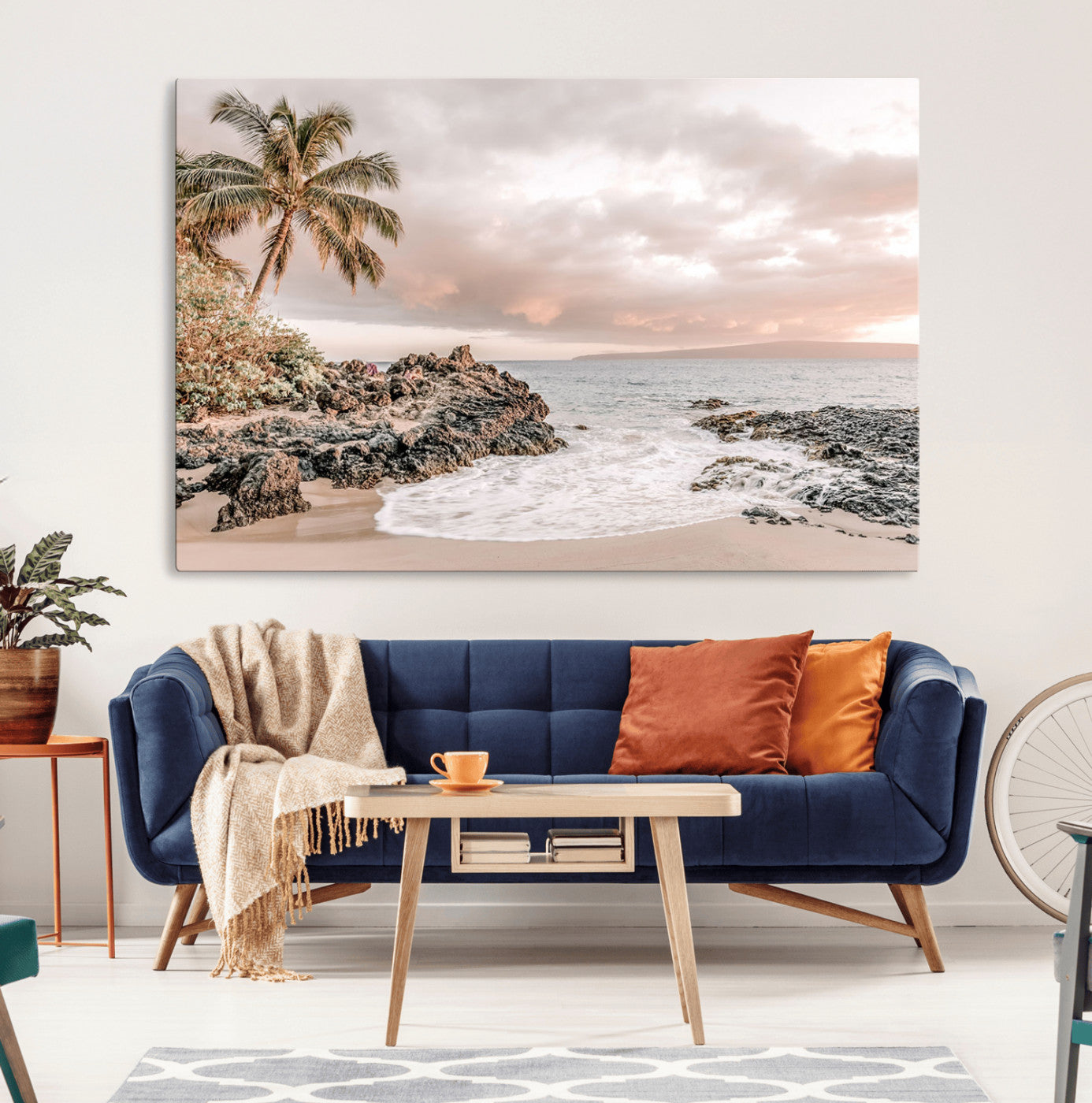 A peaceful beach scene with a palm tree and rocks, soft waves washing onto the shore under a soft pastel sky at sunset.
